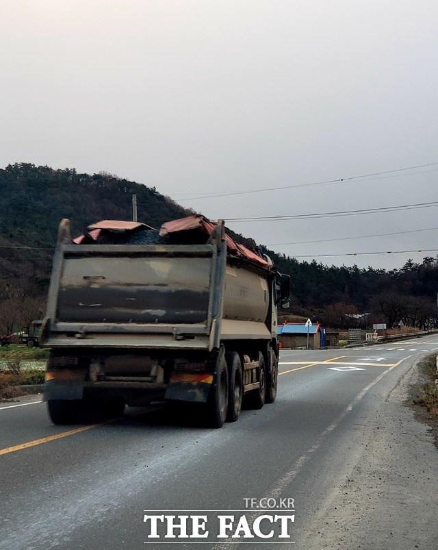 문평면 북동리에서 분진 때문인지 번호판도 보이지 않는 대형 덤프트럭이 중앙선을 넘나들며 운행하고 있다. / 이병석 기자