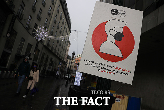 2일(현지시간) 벨기에 브리쉘에서 사람들이 코로나19에 대한 방역 지침을 보여주는 피켓을 들고 있다. 벨기에는 지난 11월 26일 오미크론 변종 확진자가 발생한 바 있다. /브뤼셀=AP.뉴시스
