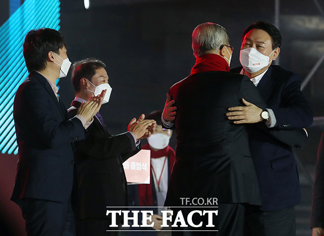 윤석열 국민의힘 대선 후보(오른쪽)가 출범식에서 김종인 총괄선대위원장(가운데)에게 빨간 목도리를 둘러준 뒤 포옹하고 있다. /국회사진취재단