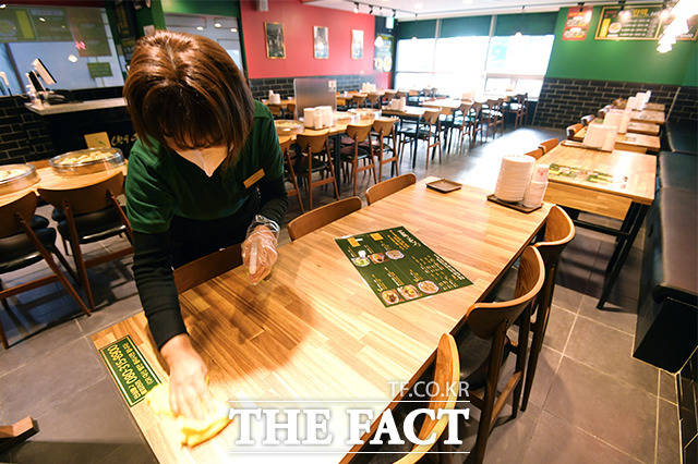 6일 오전 서울 여의도의 한 음식점에서 종업원이 매장 내부를 소독하고 있다. /이선화 기자