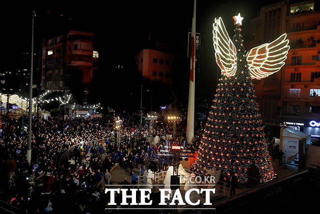 7일(현지시간) 레바논 베이루트 아크라피에 지역의 한 광장에서 크리스마스 축제가 시작돼 시민들이 대형 크리스마스트리 주변에 모여 있다. /베이루트=AP.뉴시스