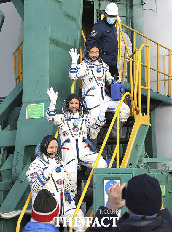 일본 프로듀서 히라노 요조와 일본 기업인 마에자와 유사쿠, 러시아 우주비행사 알렉산더 미수르킨(위쪽부터)이 8일(현지시간) 카자흐스탄 바이코누르 우주기지에서 소유즈 MS-20 우주선에 탑승하며 손을 흔들고 있다. /카자흐스탄=AP.뉴시스