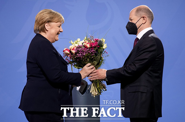 앙겔라 메르켈 전 독일 총리(왼쪽)에게 꽃다발 전하는 올라프 숄츠 신임 독일 총리.