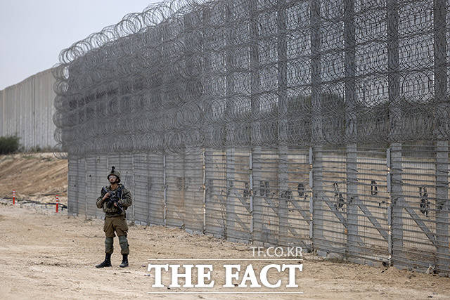 7일(현지시간) 이스라엘과 팔레스타인 가자지구 경계에 설치된 장벽 앞에서 이스라엘 군인이 경계 근무를 서고 있다. /가자지구=AP.뉴시스