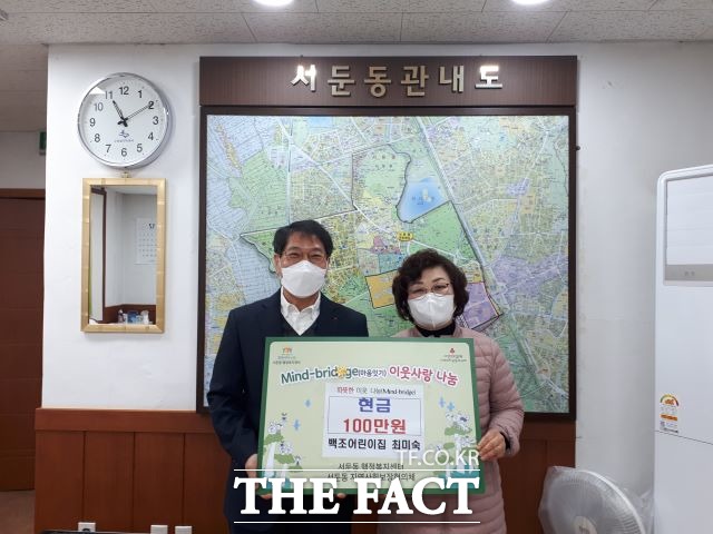 최미숙(오른쪽) 위원장이 김도형 수원시 서둔동장에게 성금을 전달하고 있다.