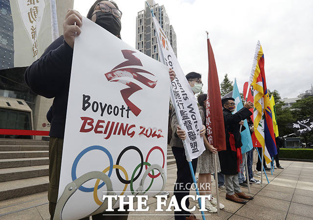 유엔 국제 인권의 날인 10일(현지시간) 대만 타이베이 중국은행 건물 앞에서 인권단체 회원들이 2022 베이징 동계올림픽 보이콧을 외치며 피켓을 들어보이고 있다. /타이베이=AP.뉴시스