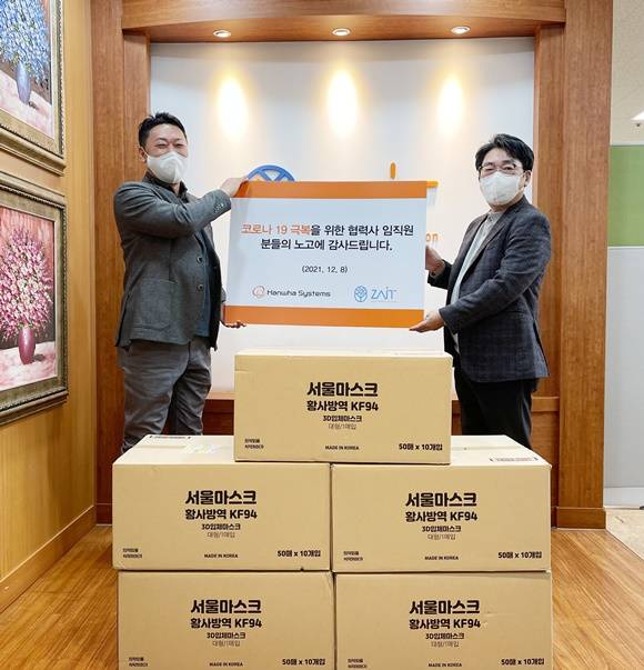 한화시스템이 중소협력사들의 원활한 자금 운용을 돕기 위해 95억 원 규모의 거래 대금을 조기 지급하기로 했다. 사진은 코로나19 극복 차원에서 정선원 한화시스템 지속가능경영팀장(왼쪽)이 협력사 ㈜자이트 솔루션 강성철 대표이사에게 KF94 마스크를 지원하는 모습. /한화시스템 제공