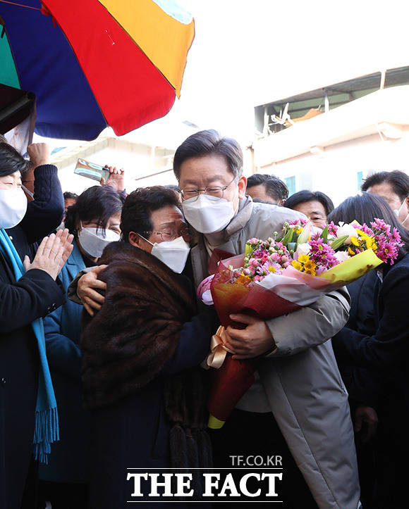 이재명 더불어민주당 대선 후보와 부인 김혜경 씨가 12일 경북 예천읍 상설시장을 방문해 한 어르신과 인사를 나누며 포옹을 하고 있다./이재명 캠프 제공