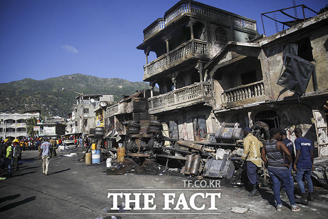 14일(현지시간) 아이티 카프아이시앵에서 유조차가 전복돼 폭발한 가운데 소방관들이 현장을 살피고 있다. /카프아이시앵=AP.뉴시스