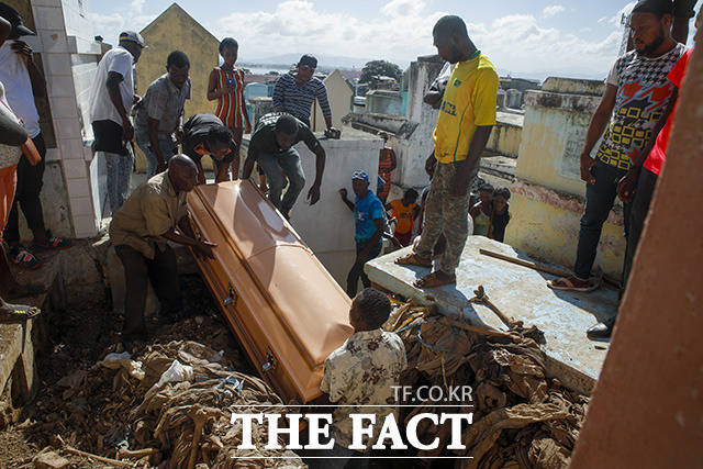 15일(현지시간) 아이티 카프아이시앵에서 유조차 폭발로 희생된 한 여성의 친인척들이 피해 여성을 매장하고 있다. /카프아이시앵=AP.뉴시스