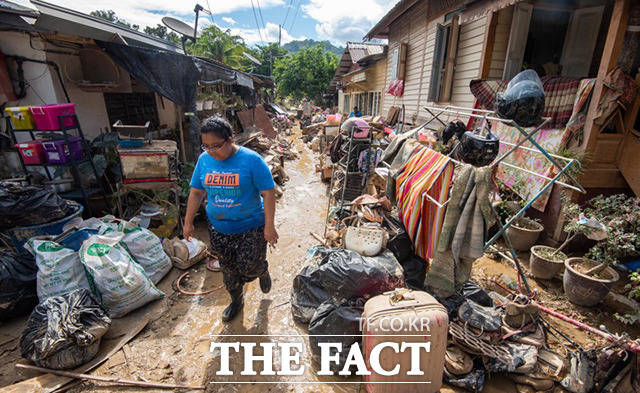 21일(현지시간) 말레이시아 서부 슬랑고르주의 훌루 랑가트에서 큰 홍수가 발생한 가운데 한 주민이 폐허가 된 주택가를 걷고 있다. /훌루 랑가트=신화.뉴시스