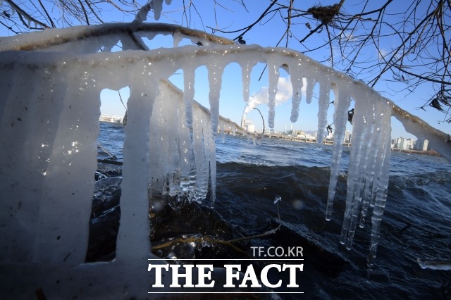 성탄절 한파가 찾아온 25일 오전 서울 여의도 한강 주변에 맺힌 고드름 너머로 보이는 당인리발전소에서 수증기 연기가 뿜어져 나오고 있다. / 남윤호 기자