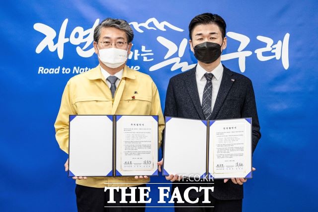 김순호 구례군수와 ㈜나바프로덕션그룹 원일령 대표가 구례군수실에서 ‘Santa’s Adventure 테마파크‘ 조성 투자협약서를 펼쳐 보이고 있다. /구례군 제공