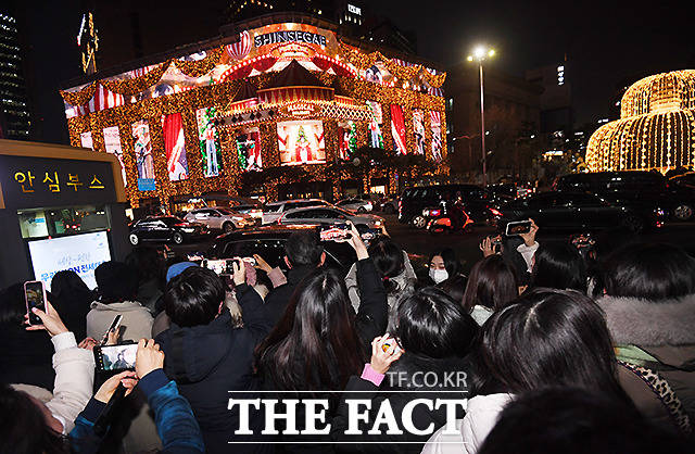 서울 중구 신세계백화점 본점 맞은편 서울중앙우체국 앞 광장에 백화점 외벽의 미디어 파사드 전시를 보기 위해 모인 시민들로 붐비고 있다.