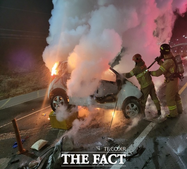 창원시 진해구 죽곡동 어은교차로 인근 진해대로 부산방면 편도 2차선 도로에서 K5 승용차와 스파크 승용차가 충돌한 뒤 화재가 발생해 소방대원이 화재를 진압하고 있다./창원소방본부 제공