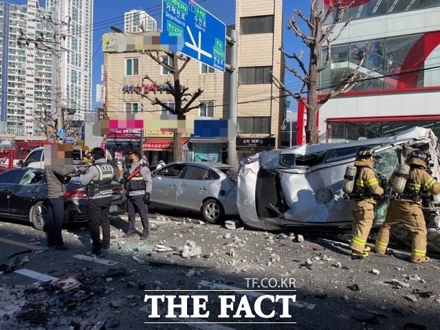 부산의 한 대형마트 주차장에서 택시가 벽을 뚫고 도로로 추락, 신호 대기 중이던 차량 13대를 덮쳐 8명이 다쳤다./부산경찰청 제공.