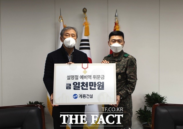 계룡건설 한승구 회장(왼쪽)이 13일 육군본부 고태남 인사사령관(오늘쪽)에게 ‘설 명절 예비역 위문금’을 전달하고 있다. / 계룡건설 제공