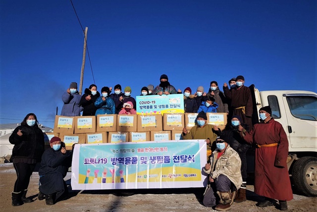 몽골 카스 희망의 숲 인근 하늘마을 주민들이 푸른아시아의 현지 활동가와 따숨박스 전달식에 참석해 기념사진을 찍고 있다. /오비맥주 제공