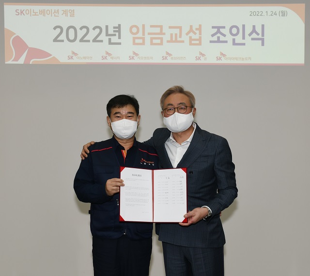 김준 SK이노베이션 부회장(오른쪽)과 이성훈 노조위원장이 24일 열린 2022년 임금협상 조인식에서 기념사진을 촬영하고 있다. /SK이노베이션 제공