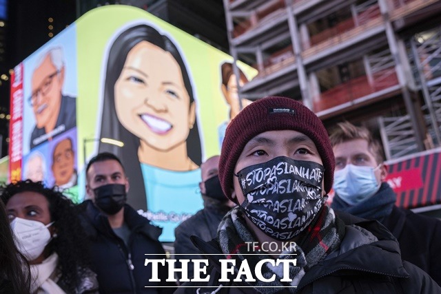 뉴욕 타임스퀘어에서 한 남성이 #아시안 증오 범죄 그만이라고 적힌 마스크를 쓴 채 인종차별 범죄 희생자를 추모하고 있다. 지난달 18일 뉴욕 타임스퀘어에서 열린 인종차별 범죄 비판 시위 당시. /AP.뉴시스