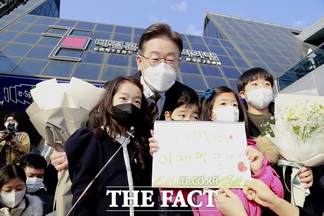 12일 대전을 찾은 이재명 더불어민주당 대선 후보(사진 오른쪽)가 꽃다발을 받은 뒤 기념촬영을 하고 있다. / 대전 = 김성서 기자