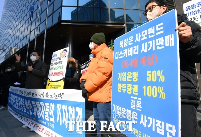 디스커버리펀드 진실규명을 위한 피해자들의 기자회견이 16일 오전 서울 을지로 기업은행 본사 앞에서 열린 가운데 피해자들이 손피켓을 들어보이고 있다. /남용희 기자