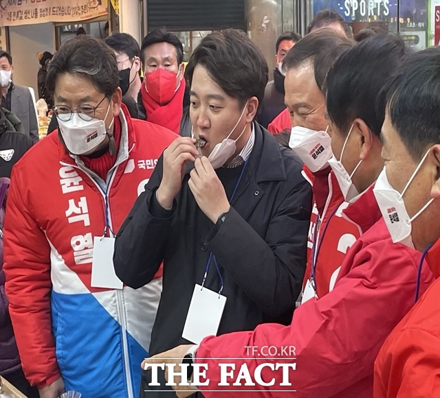 김해 외동전통시장에서 상인이 건넨 전통과자를 먹는 국민의힘 이준석 대표./김해=강보금 기자