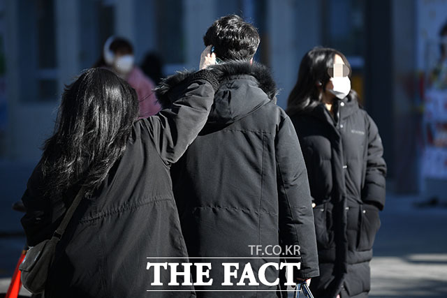 18일 전국이 대체로 맑ㄱ고 낮기온이 조금 오르겠지만 여전히 추운 날씨가 이어지겠다. 서울 홍대 거리를 찾은 시민들이 핫팩으로 귀와 손을 녹이고 있다./더팩트 남윤효 기자