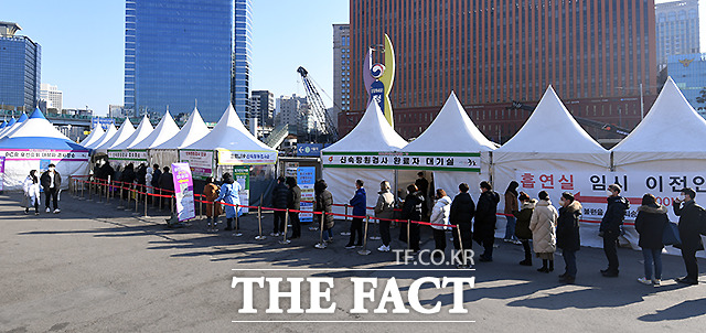 18일 서울역 광장 임시선별검사소를 찾은 시민들이 검사를 받기 위해 길게 줄 서 있다.