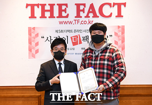 제5회 더팩트 온라인 사진 공모전 사진이 더 팩트다! 시상식이 22일 오후 서울 마포구 더팩트 사옥에서 열린 가운데 스마트폰 부문 최우수상을 수상한 최현석 씨(오른쪽)가 박순규 더팩트 편집국장과 기념촬영을 하고 있다. /남용희 기자
