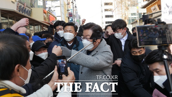 이재명 후보가 22일 오후 인천 구월 로데오 광장 유세차로 오는 동안 환호하는 지지자들과 주먹 악수를 하고 있다. /인천=지우현 기자