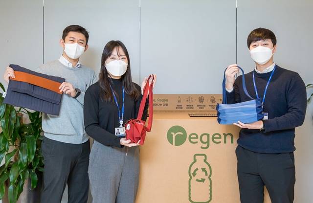 효성티앤씨 직원들이 사내 페트병 수거함 앞에서 친환경 섬유 리젠으로 만든 가방을 소개하고 있다. /효성 제공