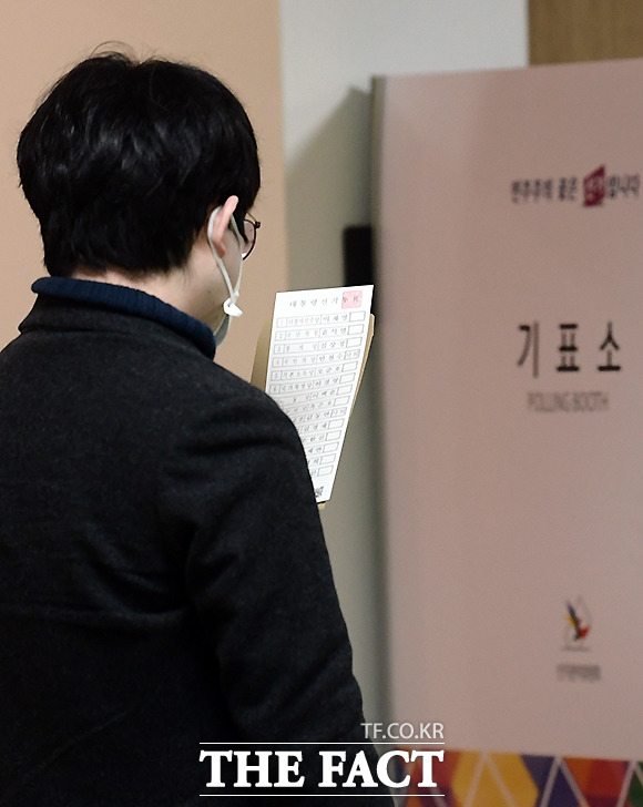 제 20대 대통령선거 사전투표 첫날인 4일 오전 서울 서초구 서초4동 열린문화센터에 마련된 사전투표소를 찾은 한 유권자가 투표에 앞서 용지를 살피고 있다.