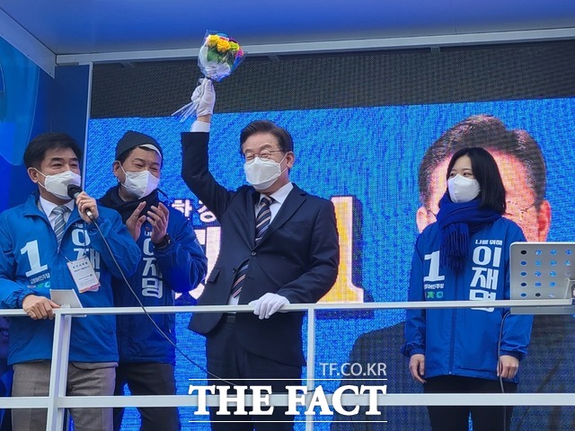 세계 여성의 날을 맞아 박지현 민주당 선대위 디지털성범죄근절특위 위원장에게 꽃다발을 전해주는 이재명 후보. 송영길 당 대표도 이 후보의 뒷편에 서서 박수를 치고 있다. /송다영 기자.