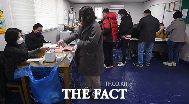 신분 확인을 마친 유권자들이 투표 용지를 받고 있다.