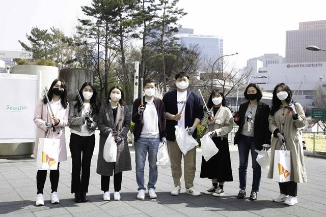 나경수(왼쪽에서 네 번째) SK지오센트릭 사장과 신입사원들이 6일 서울로 주변에서 폐플라스틱 등 쓰레기를 줍는 플로깅을 한 뒤 기념사진을 촬영하고 있다. /SK지오센트릭 제공
