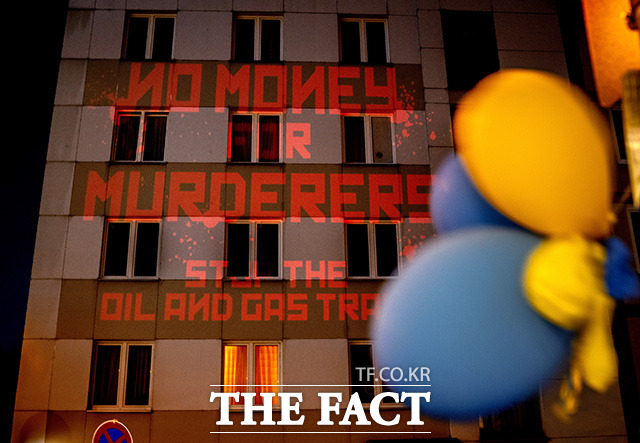 독일 프랑크푸르트 러시아 영사관에 살인자에게 쓸 돈은 없다, 석유와 가스 거래 중단이라는 문구가 투사되고 있다.