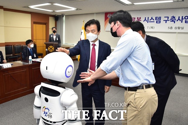 조규일 진주시장이 민원안내 로봇 ‘에나봇’의 민원업무 안내 기능과 로봇댄스 등의 부가적인 기능을 살피고 있다./진주시 제공