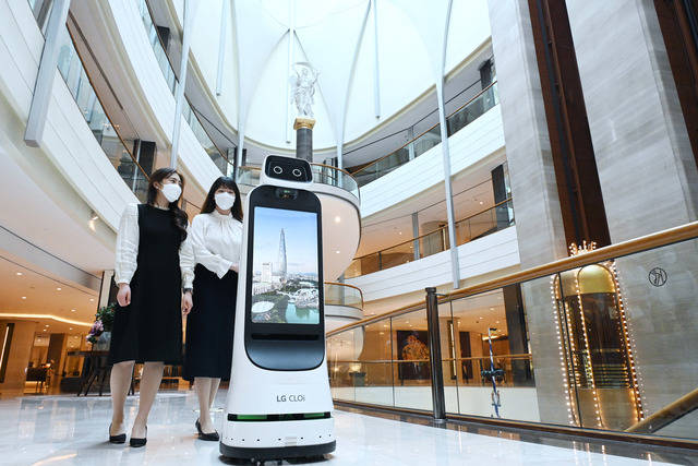 LG 클로이 가이드봇(LG CLOi GuideBot)이 서울 잠실 소재 롯데호텔 월드에서 고객들을 맞이한다. 이번 안내로봇 공급을 계기로 양사는 함께 LG 클로이 로봇을 활용한 비대면 서비스를 지속 확대해 나갈 계획이다. 고객들이 LG 클로이 가이드봇의 안내에 따라 이동하고 있다. /LG전자 제공