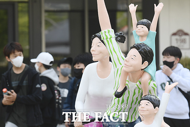 서울 광화문 대한민국역사박물관 앞 조형물과 마스크를 착용한 학생들이 대조된 모습을 보이고 있다.