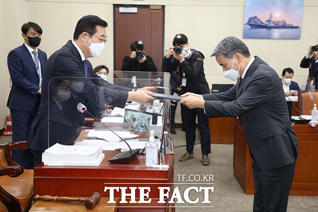 이종섭 국방부장관 후보자(오른쪽)가 민홍철 국방위원장에게 선서문을 제출하고 있다.