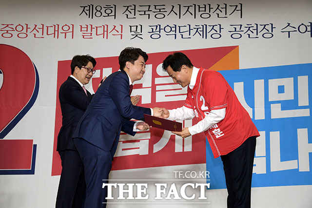 오세훈 서울시장 후보가 이준석 위원장에게 공천장을 받고 있다.