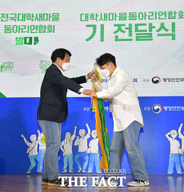 전국대학새마을동아리연합회 박준영 초대 회장(오른쪽)에게 깃발 전달하는 염홍철 회장.