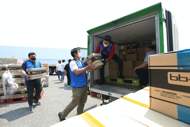 BBQ 직원과 푸드뱅크 관계자가 기부할 제품을 차량으로 옮기고 있다. /제너시스BBQ 제공