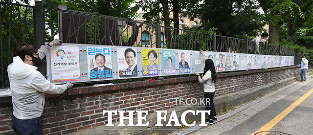 제8회 전국동시지방선거 공식 선거운동이 시작된 19일 오후 서울 종로구 이화동 일대에서 선거관리위원회 관계자들이 선거 벽보를 부착하고 있다. /남용희 기자
