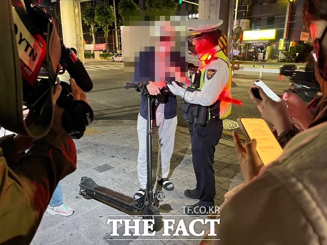 30일 오후 11시쯤 서울 광진구 건대사거리 인근에서 헬멧을 착용하지 않은 채 전동킥보드를 타던 20대 남성이 경찰에 적발됐다. /최의종 기자