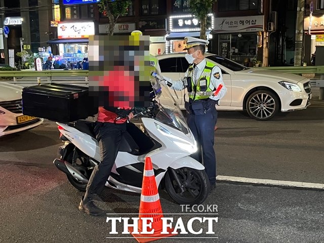 30일 오후 10시쯤 서울 광진구 자양사거리 인근에서 경찰이 지나가던 오토바이 탑승자의 음주 여부를 확인하고 있다. /최의종 기자