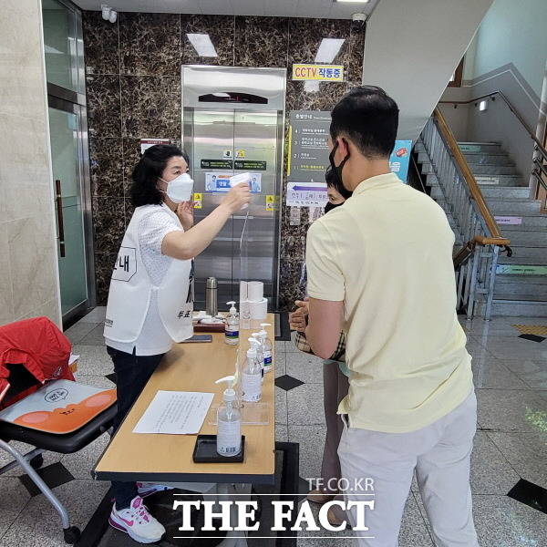 경기 안산시 당원구 선부1동 선부1투표소 입구에서 투표관계자가 유권자에게 세정제로 소독하고 있다./안산=이상묵 기자