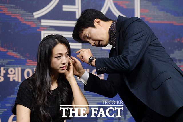 배우 박해일(오른쪽)이 2일 오전 서울 동대문구 JW 메리어트 동대문 스퀘어 서울에서 열린 영화 헤어질 결심 제작보고회에서 탕웨이의 통역 인이어 착용을 돕고 있다. /이선화 기자