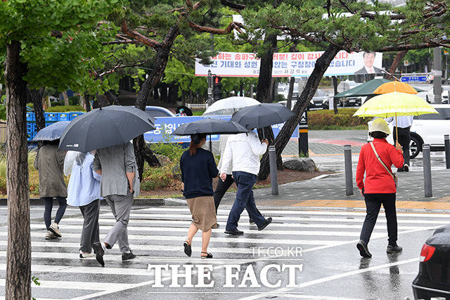 전국적으로 비가 내리는 가운데 우산을 쓴 채 발걸음을 옮기는 시민들.